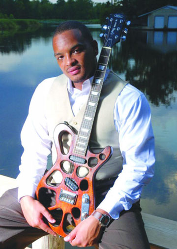 Jarekus Singleton holds his guitar.