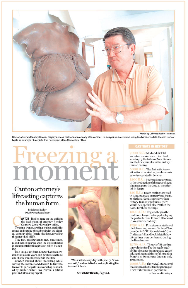 A man poses next to a torso of one of his life casts for a feature story about the art.