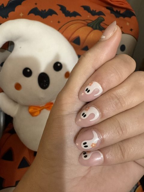 A picture of the Kiss Haunt Cursed But Cute nails featuring pink and white swirling ghosts with a plush ghost in the background.